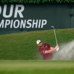 Golfer hitting a sand shot during a championship event.